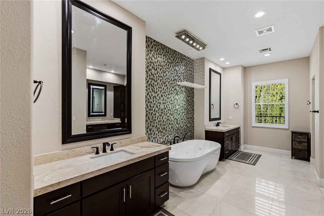 204 Satin Mist Court, Las Vegas, NV 89144 Polished tile flooring and a sleek freestanding tub define this contemporary bathroom retreat.
