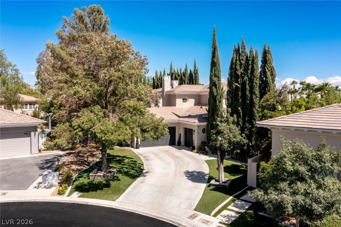 204 Satin Mist Court, Las Vegas, NV 89144 Towering trees frame the curved concrete driveway leading to this multi-level tile-roofed residence.
