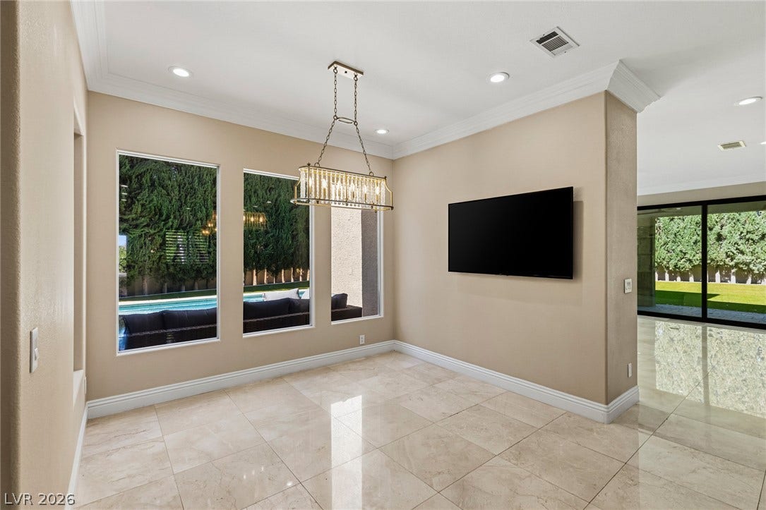 204 Satin Mist Court, Las Vegas, NV 89144 Polished tile flooring and crown molding frame a sunlit dining space overlooking the pool.