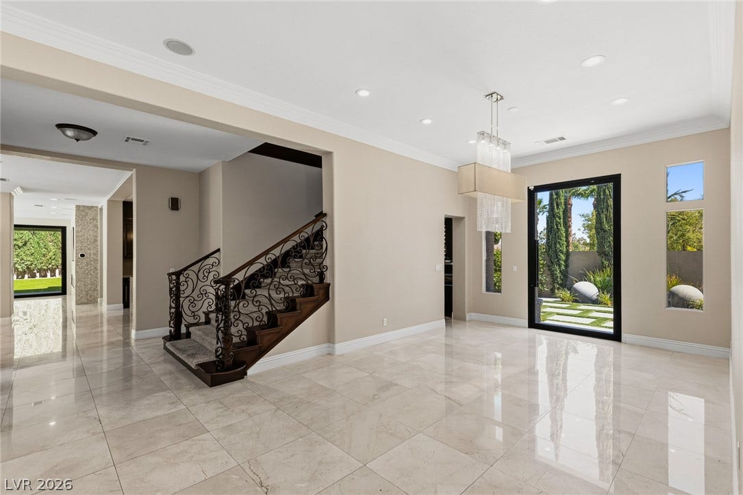 204 Satin Mist Court, Las Vegas, NV 89144 Polished tile flooring and an elegant wrought-iron staircase define this grand, light-filled entryway.