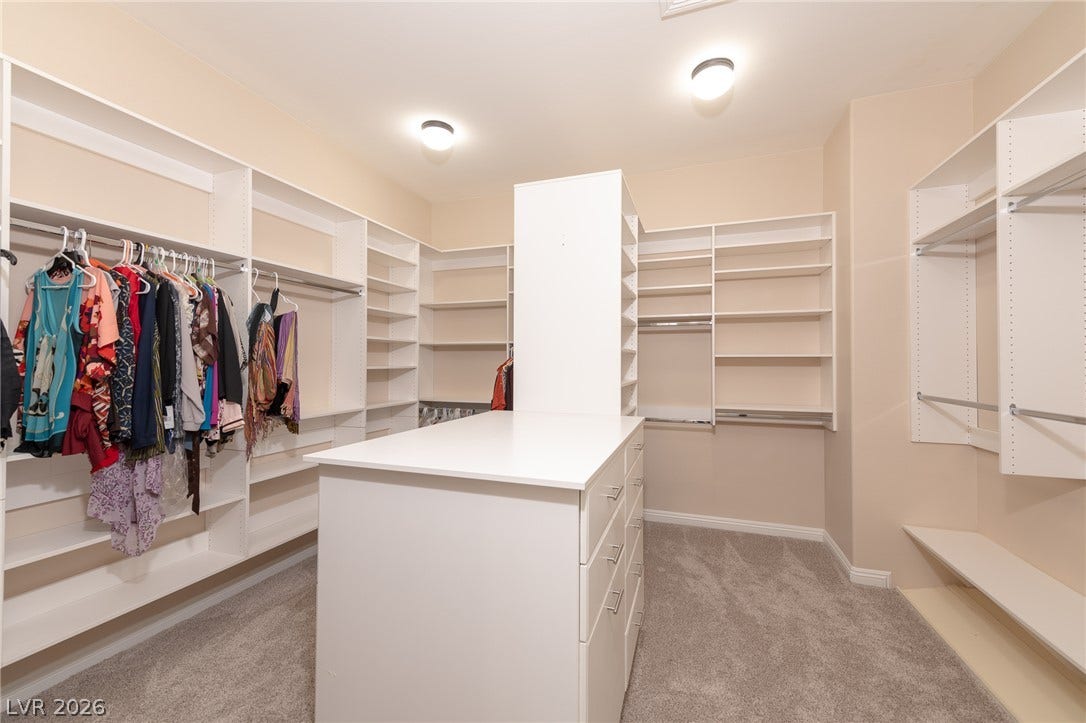 204 Satin Mist Court, Las Vegas, NV 89144 A spacious custom walk-in closet boasts extensive built-in shelving and a central storage island.