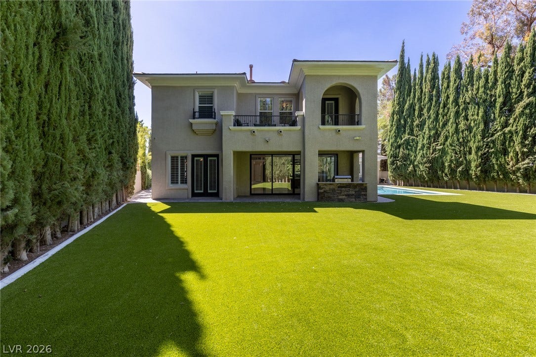 204 Satin Mist Court, Las Vegas, NV 89144 An manicured lawn leads to a stucco exterior with archways, balconies, and private outdoor spaces.