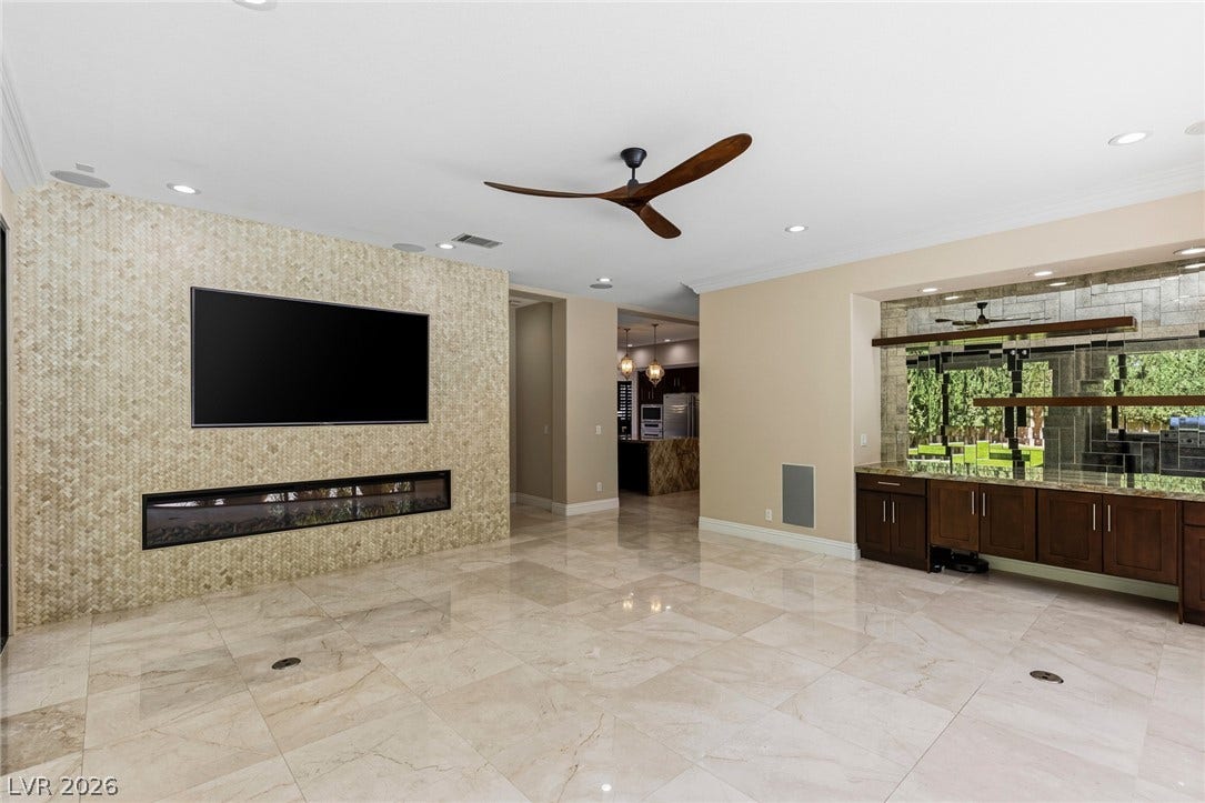 204 Satin Mist Court, Las Vegas, NV 89144 Polished stone flooring and a linear fireplace define this modern living area.