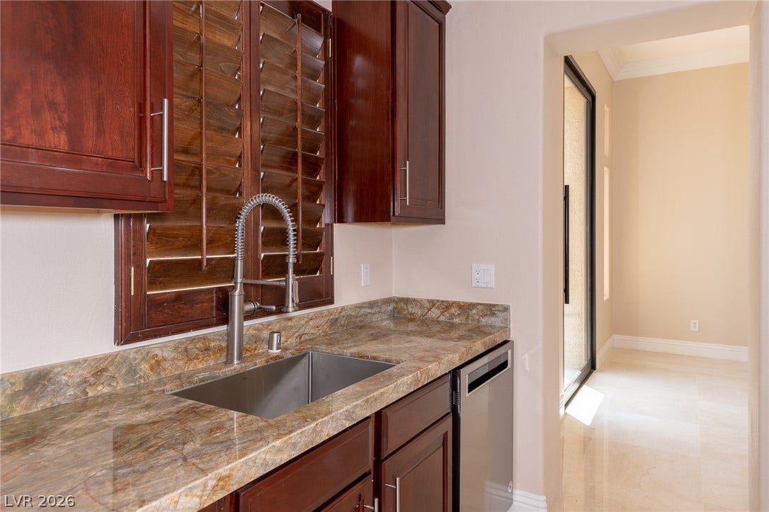 204 Satin Mist Court, Las Vegas, NV 89144 Rich wood cabinetry and polished stone countertops elevate this practical bar area.
