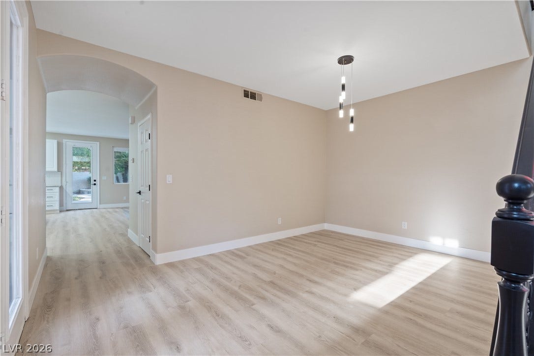 1662 Ravanusa Drive, Henderson, NV 89052 An arched doorway leads to the light-filled main level, showcasing classic wood-style floors.