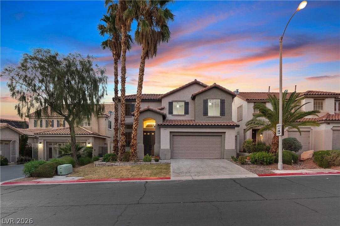 1662 Ravanusa Drive, Henderson, NV 89052 Palm trees frame a Spanish tile roof and arched entry under a vibrant twilight sky.