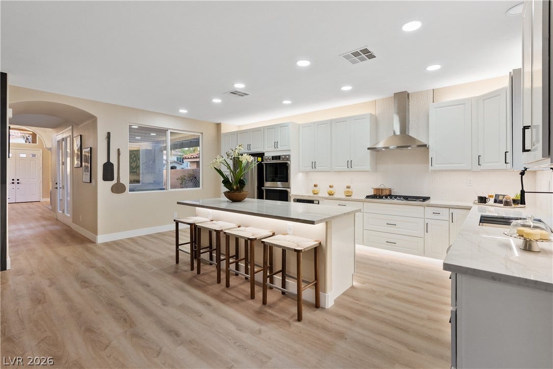 1662 Ravanusa Drive, Henderson, NV 89052 Gleaming wood-look floors anchor a spacious kitchen boasting a large center island and modern cabinetry.
