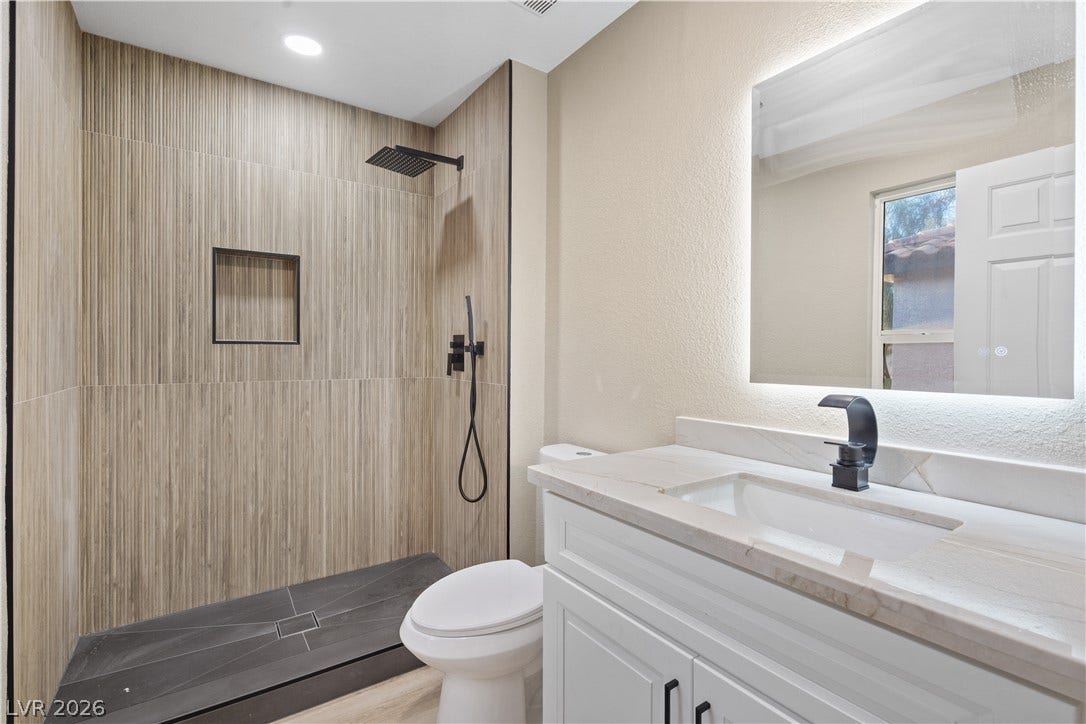 1662 Ravanusa Drive, Henderson, NV 89052 Modern stone countertops pair beautifully with textured shower tile and updated fixtures.