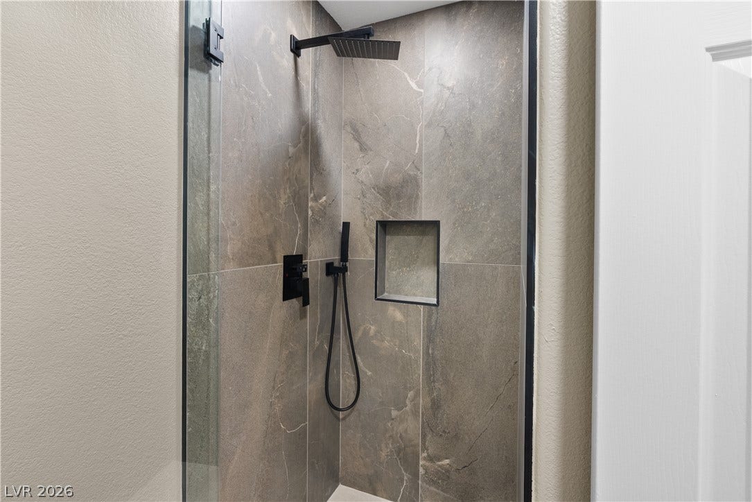 1662 Ravanusa Drive, Henderson, NV 89052 Large format stone-look tiles line this modern shower complete with a built-in storage niche.