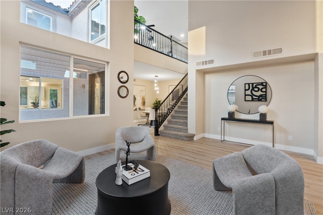 1662 Ravanusa Drive, Henderson, NV 89052 Soaring ceilings and expansive windows frame this airy, multi-level living area with elegant wood flooring.