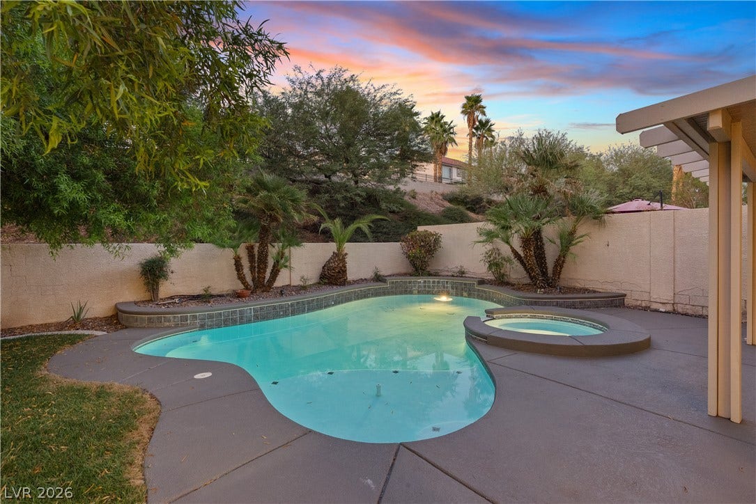 1662 Ravanusa Drive, Henderson, NV 89052 Mature palms and a concrete patio frame the inviting backyard pool and integrated spa.
