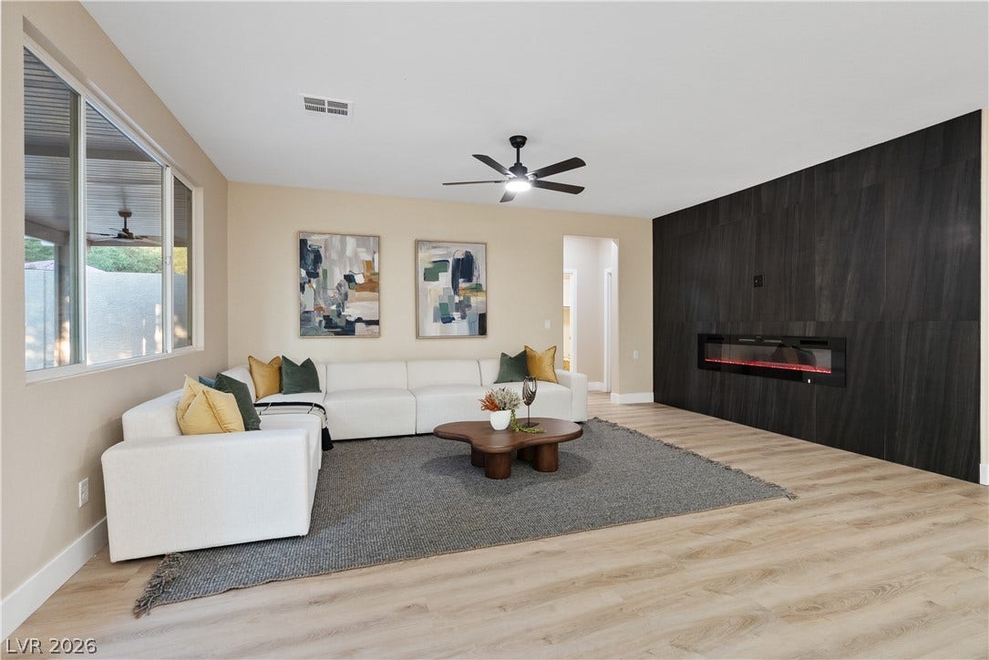 1662 Ravanusa Drive, Henderson, NV 89052 An elegant modern fireplace wall commands attention in this spacious living area with handsome wood-look flooring.