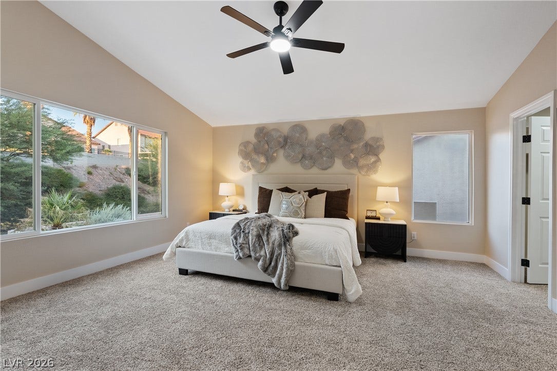 1662 Ravanusa Drive, Henderson, NV 89052 Vaulted ceilings and wide windows define this serene bedroom space.