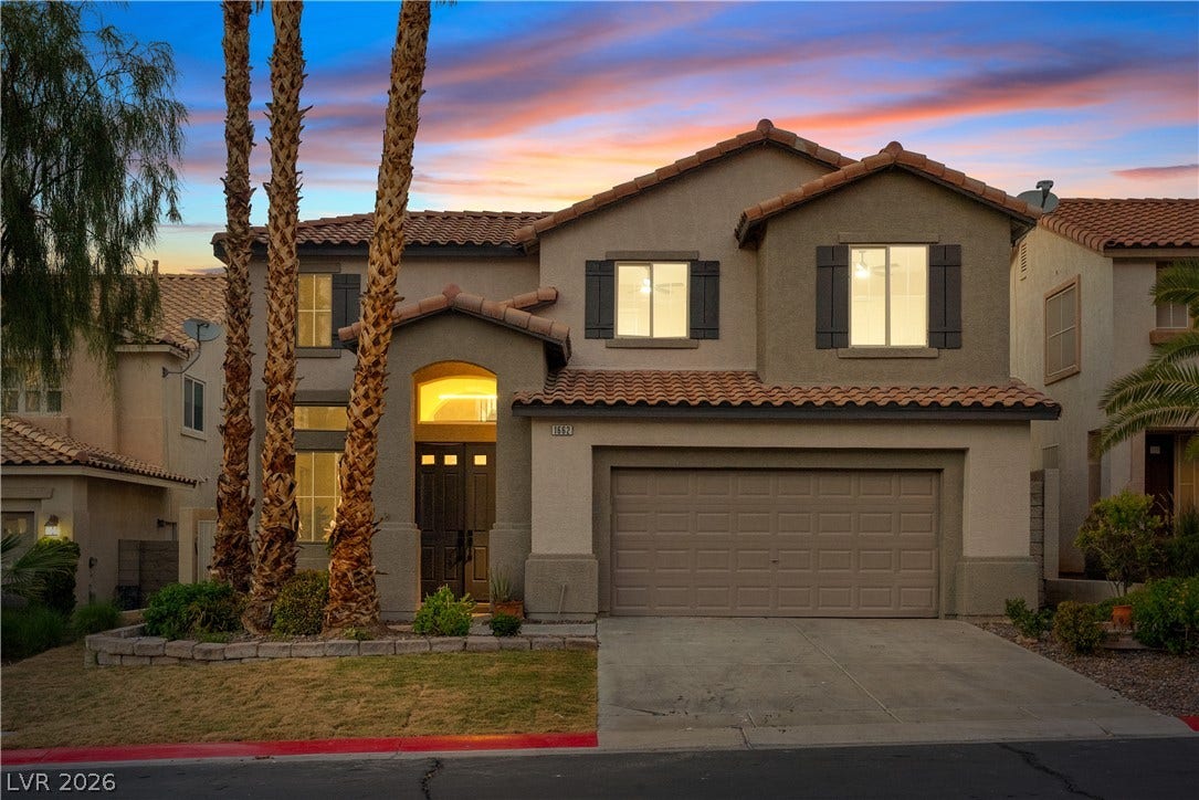 1662 Ravanusa Drive, Henderson, NV 89052 Spanish tile roofing and custom shutters highlight this multi-level home under dramatic evening skies.