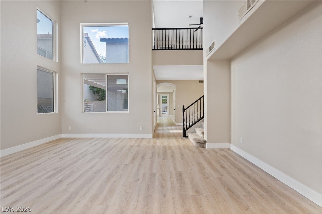 1662 Ravanusa Drive, Henderson, NV 89052 Towering double-height windows illuminate this open interior space featuring durable wide-plank flooring.