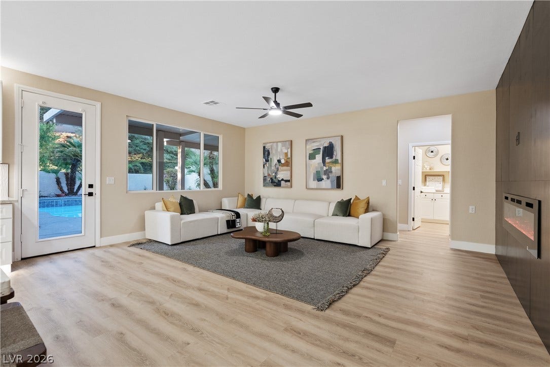1662 Ravanusa Drive, Henderson, NV 89052 Warm wood-look flooring and a modern fireplace anchor this welcoming, open living space.