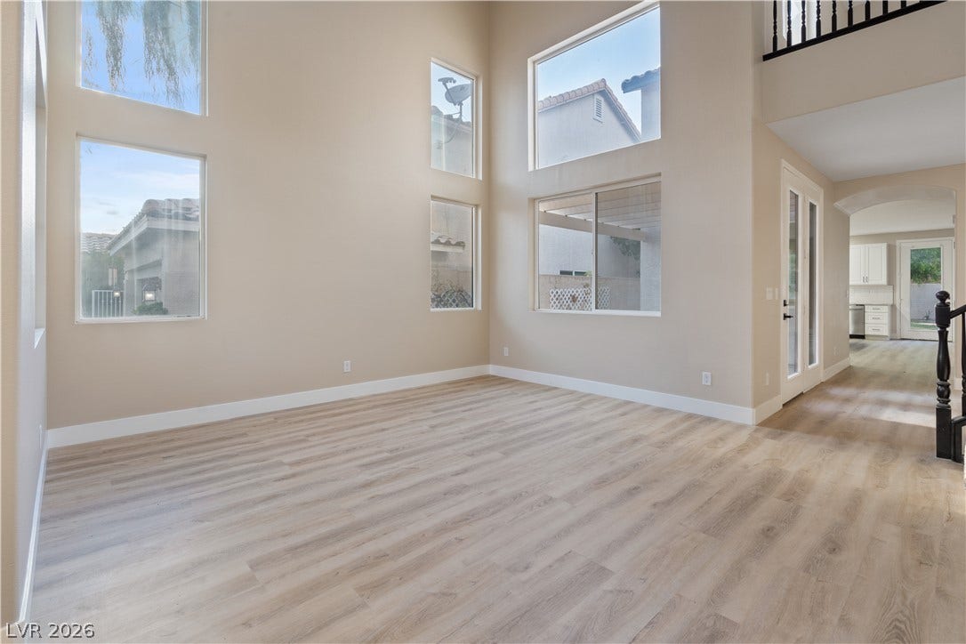 1662 Ravanusa Drive, Henderson, NV 89052 Towering ceilings and multi-tiered windows fill this airy living area with abundant natural light.