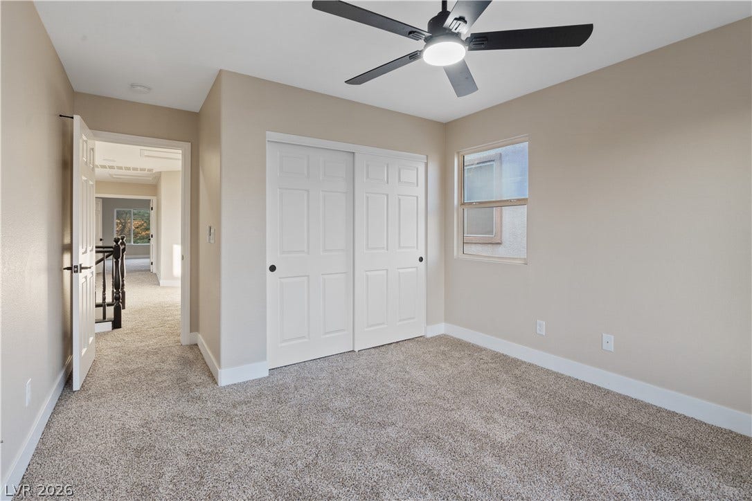 1662 Ravanusa Drive, Henderson, NV 89052 Plush carpeting anchors this comfortable bedroom featuring a sliding closet door and natural light.