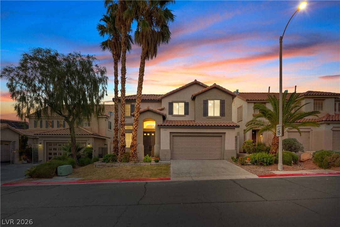 1662 Ravanusa Drive, Henderson, NV 89052 A classic stucco exterior with Spanish tile roofing stands out against a twilight sky.
