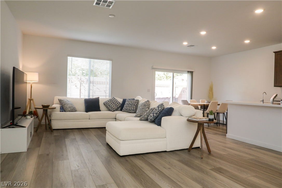 Recessed lighting illuminates this seamless open floorplan connecting the living and dining spaces.