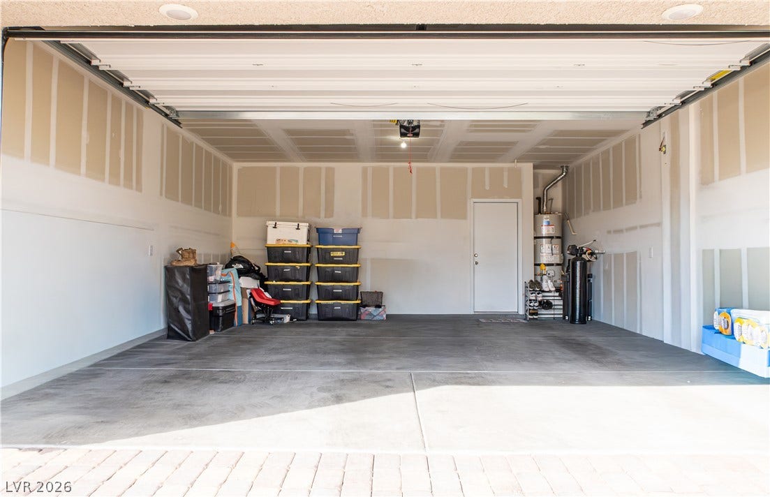 An open and functional multi-vehicle garage features durable concrete flooring and recessed lighting.