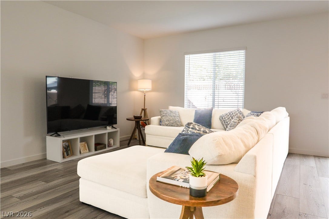 Smooth plaster walls and wide-plank wood flooring define this inviting living space.