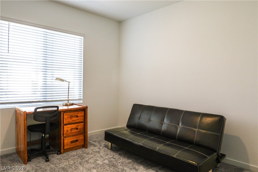 Plush carpeting anchors this versatile room with a wide window overlooking the outdoors.