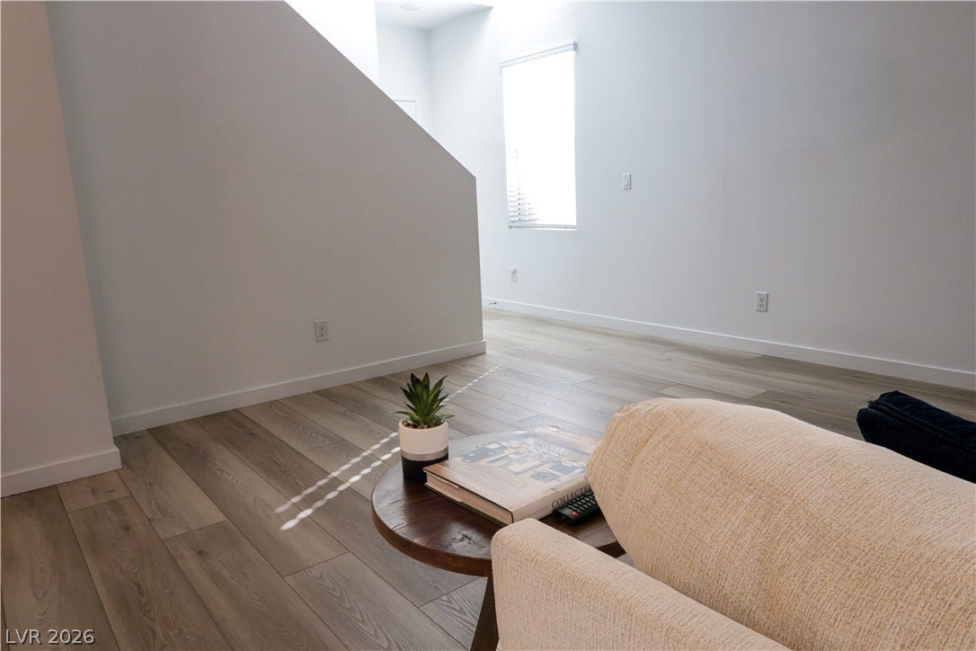 Gleaming wood-look floors complement clean white walls in this modern transition area.