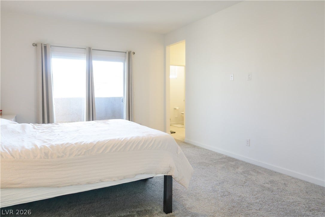 Plush carpeting anchors this bedroom suite, leading directly to an attached private bath.