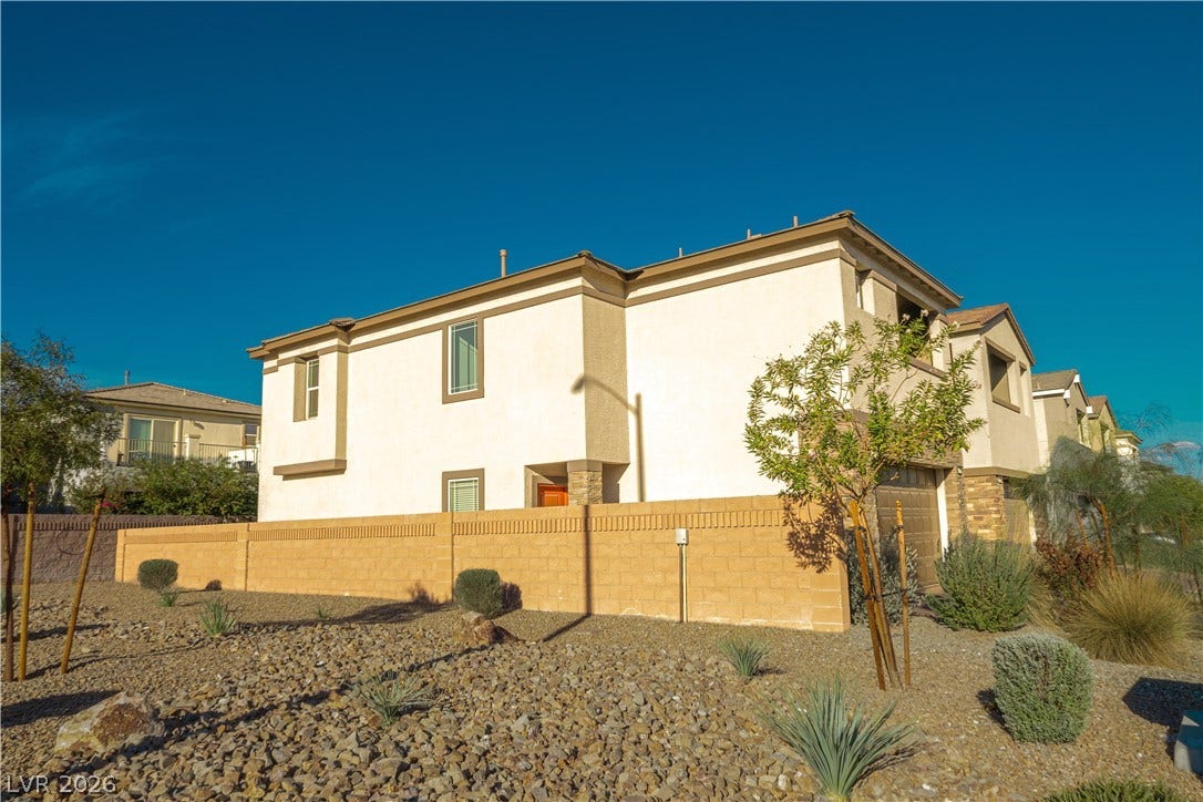 A low-maintenance desert landscape frames this multi-level home under clear blue skies.