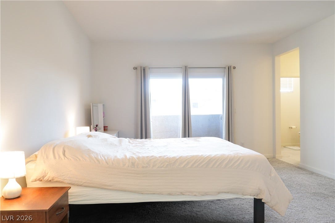 Plush carpeting and sliding glass doors create a comfortable, inviting atmosphere.