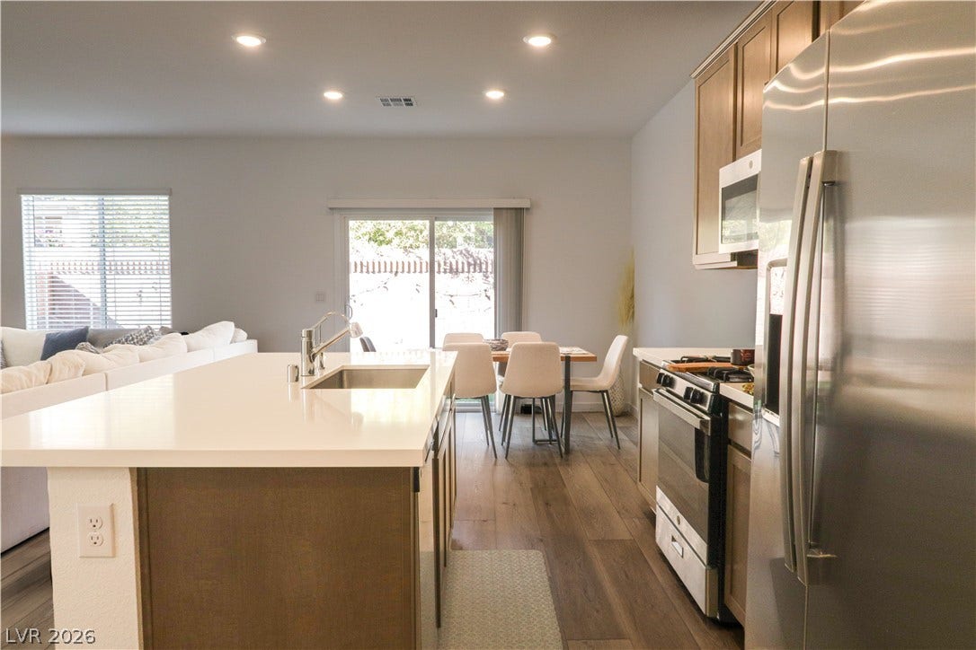 Smooth stone countertops and recessed lighting elevate this modern culinary workspace.