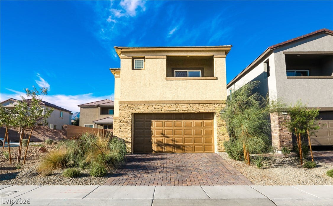 A paved driveway leads to the spacious two-car garage of this modern multi-level residence.