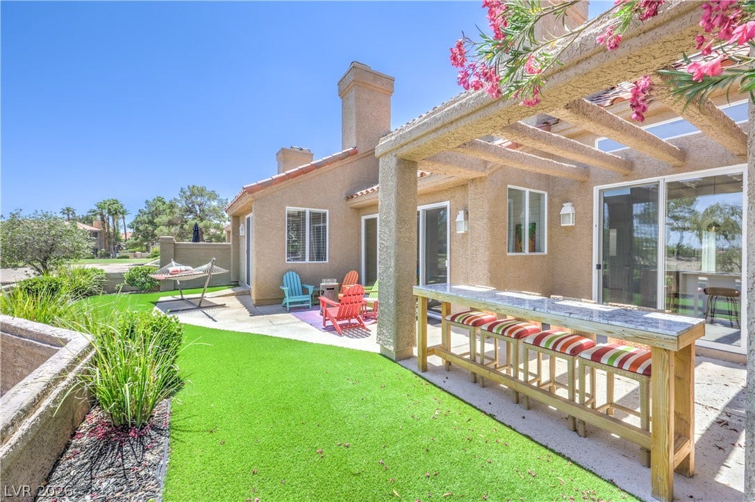8211 Round Hills Circle, Las Vegas, NV 89113 Enjoy outdoor entertaining with a dedicated patio bar and pergola, complemented by lush artificial turf landscaping and a peaceful hammock area.
