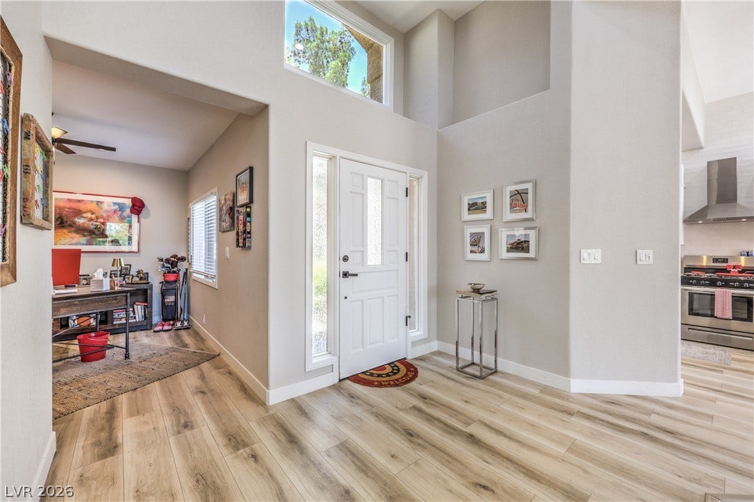 8211 Round Hills Circle, Las Vegas, NV 89113 Enter this dwelling through a bright entryway featuring a transom window, leading to a home office and a well-appointed kitchen.
