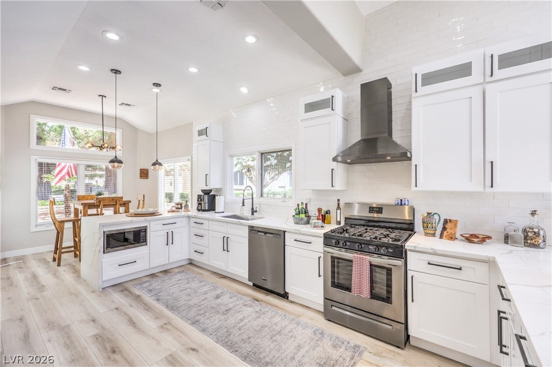8211 Round Hills Circle, Las Vegas, NV 89113 This contemporary kitchen features stainless steel appliances, crisp white cabinetry, and durable wood flooring.