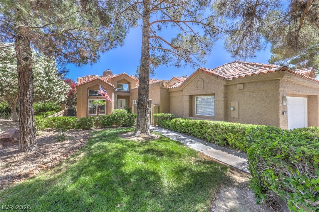 8211 Round Hills Circle, Las Vegas, NV 89113 This appealing stucco residence showcases a welcoming facade with a tile roof and mature landscaping.