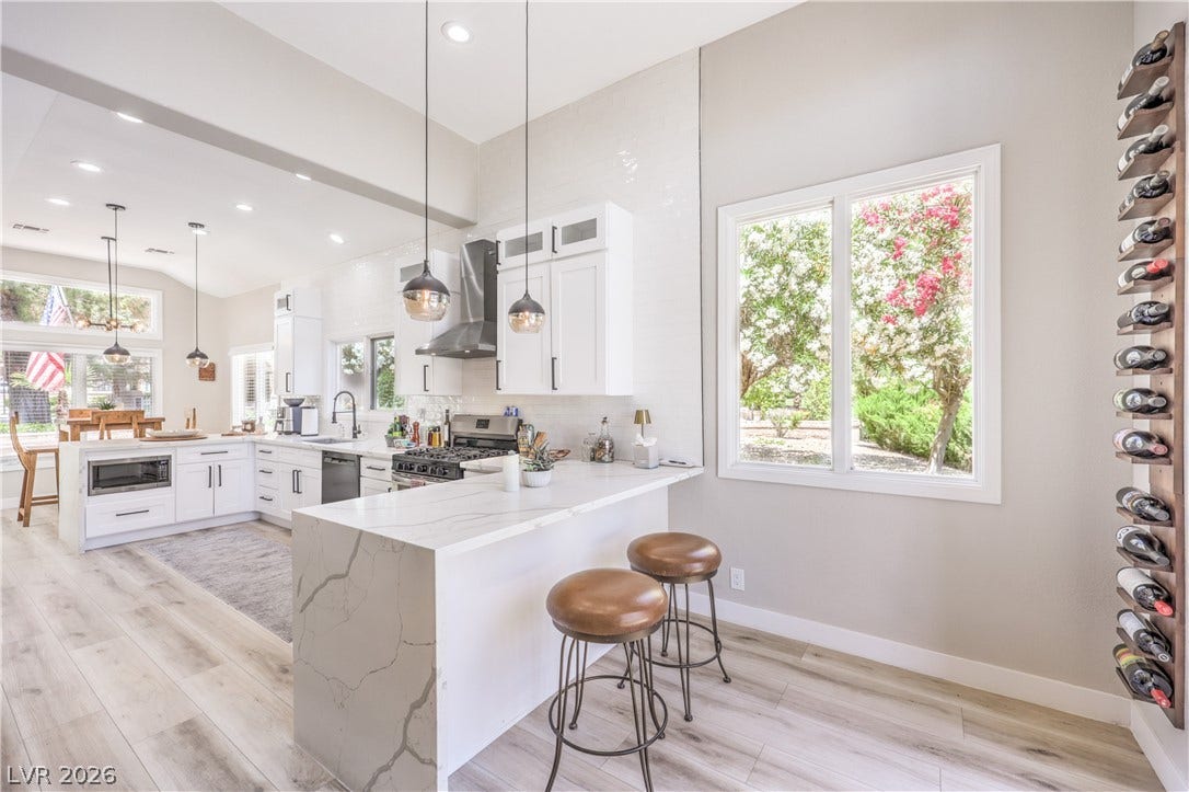 8211 Round Hills Circle, Las Vegas, NV 89113 Prepare culinary delights in this open-concept kitchen, boasting a waterfall island and ample counter space.