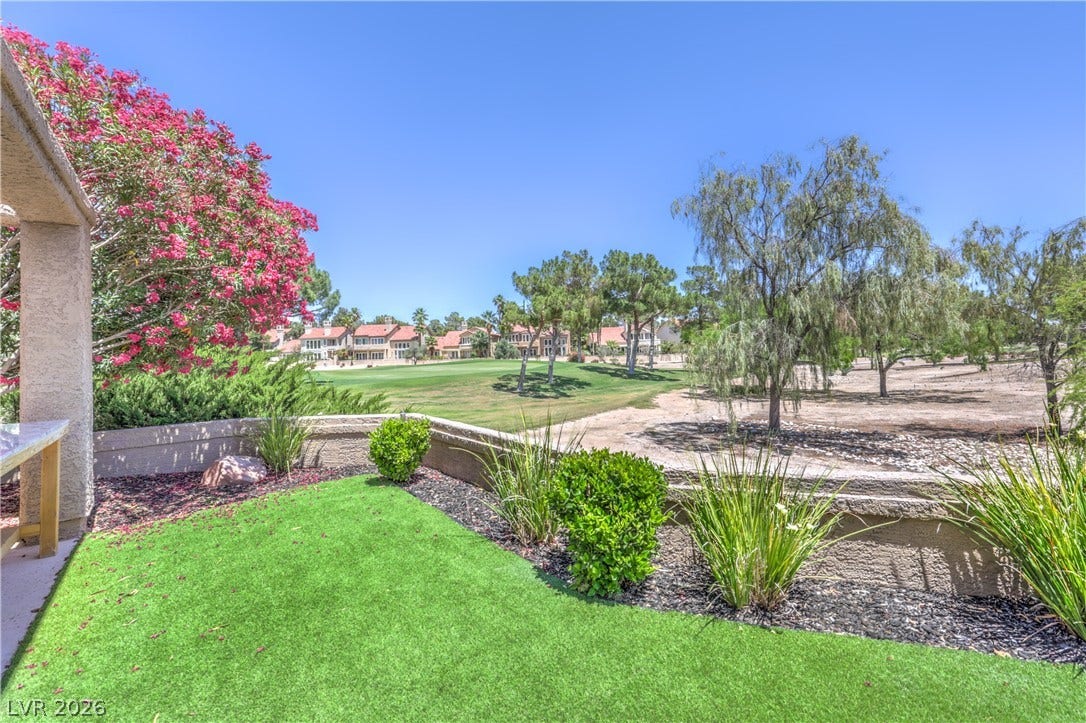 8211 Round Hills Circle, Las Vegas, NV 89113 Enjoy views of the verdant golf course from this outdoor patio space with vibrant landscaping.