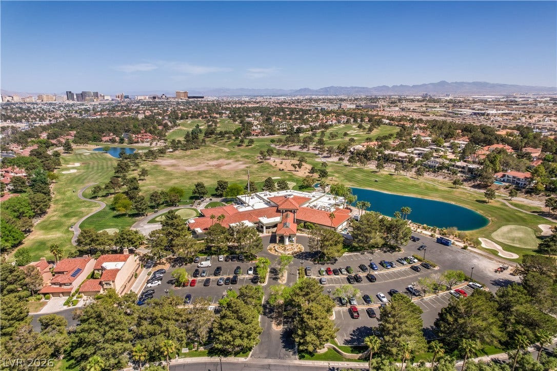 8211 Round Hills Circle, Las Vegas, NV 89113 An aerial perspective reveals a vibrant golf course community, complete with a central clubhouse and tranquil water features.