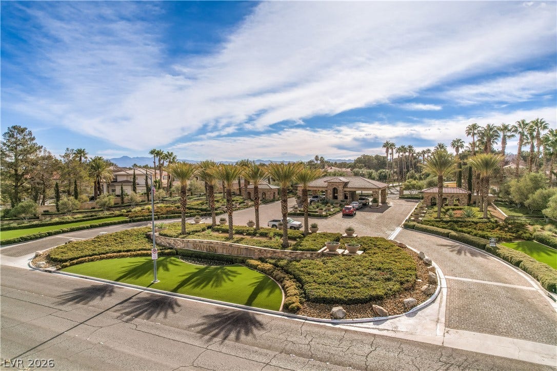 8211 Round Hills Circle, Las Vegas, NV 89113 Welcome to an exclusive community, featuring a beautifully landscaped entrance with majestic palm trees and a paved drive.