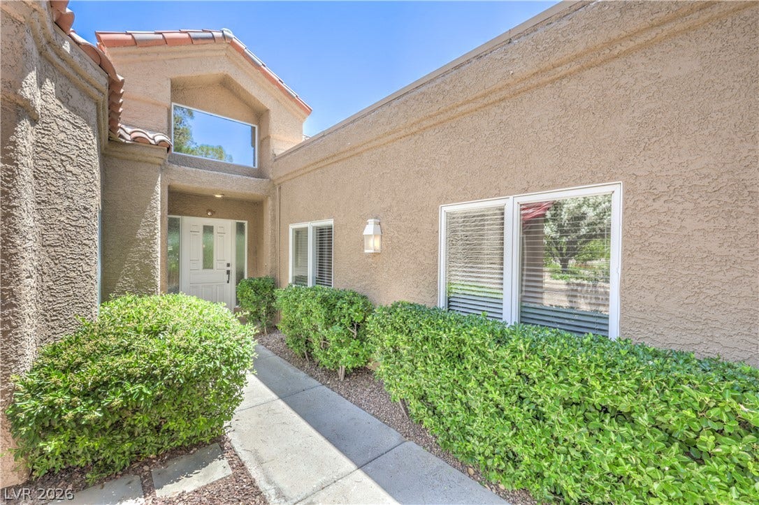 8211 Round Hills Circle, Las Vegas, NV 89113 A terracotta-tiled roofline crowns this inviting home entrance, flanked by neat, low landscaping.