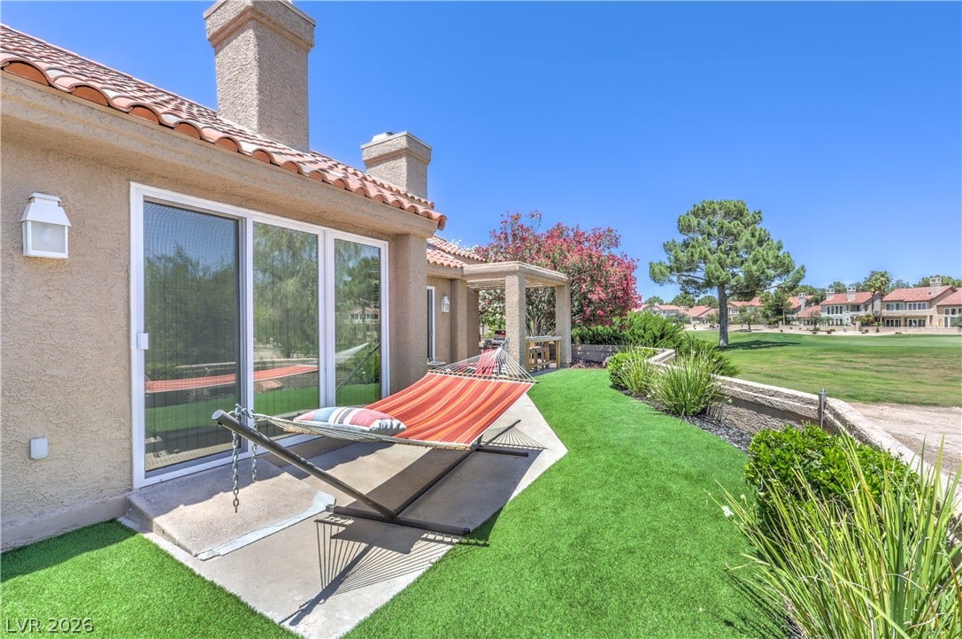 8211 Round Hills Circle, Las Vegas, NV 89113 Enjoy outdoor relaxation on the patio with a hammock, overlooking the verdant golf course.