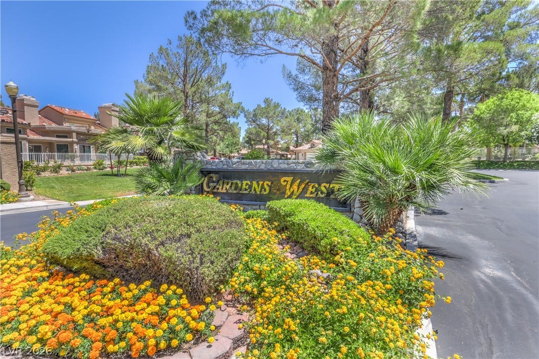 8211 Round Hills Circle, Las Vegas, NV 89113 A stone monument with gold lettering, lush landscaping, and mature trees welcomes residents to this inviting community.