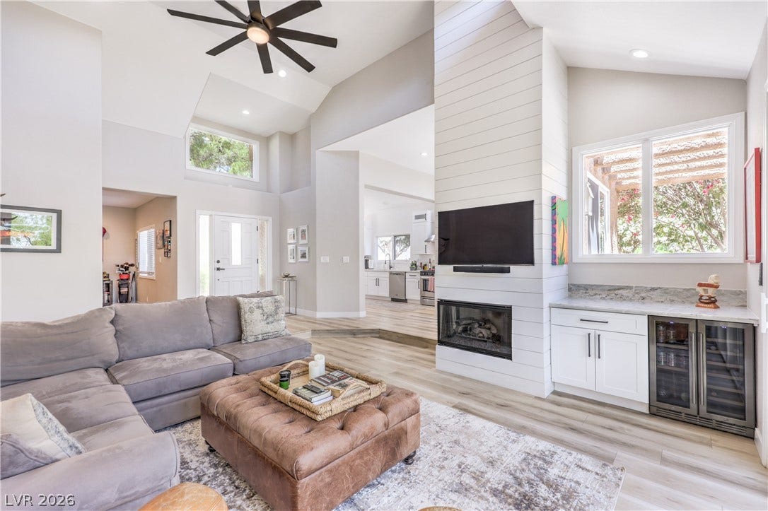 8211 Round Hills Circle, Las Vegas, NV 89113 An open concept living area boasts soaring ceilings and a cozy fireplace with a convenient wet bar.