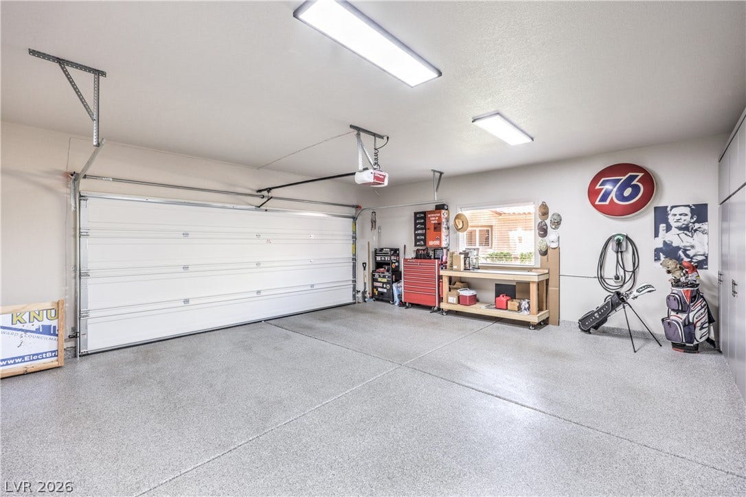 8211 Round Hills Circle, Las Vegas, NV 89113 This organized garage offers ample space for vehicles and features a convenient workbench.