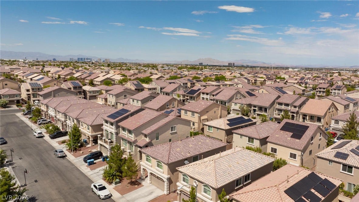 9804 Kodiak Island Court, Las Vegas, NV 89141 A quiet residential street winds through a suburban neighborhood of modern multi-level homes.