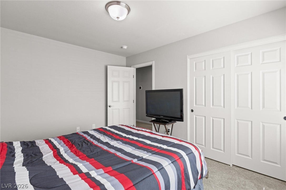9804 Kodiak Island Court, Las Vegas, NV 89141 Plush carpeting and expansive closet doors highlight this quiet secondary bedroom.