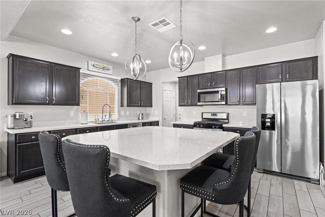 9804 Kodiak Island Court, Las Vegas, NV 89141 A spacious kitchen features a large central island, stone countertops, and extensive cabinetry.