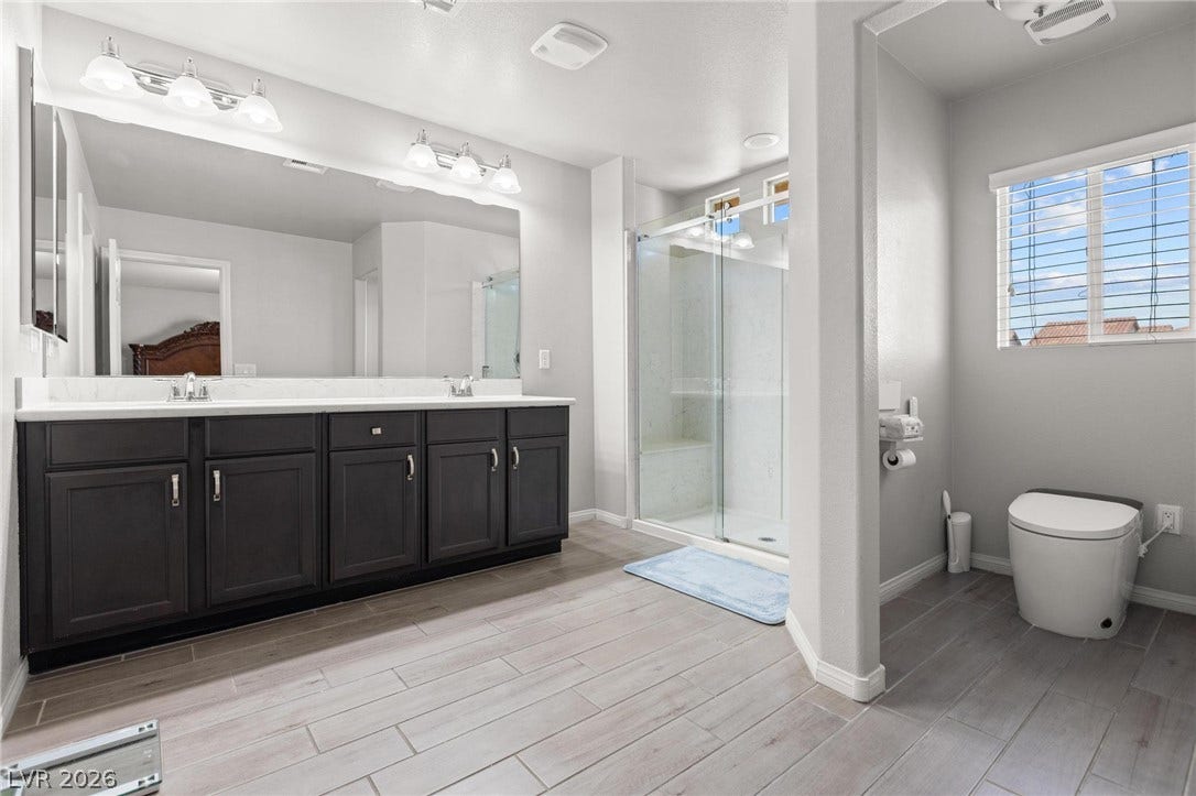 9804 Kodiak Island Court, Las Vegas, NV 89141 Double vanities and a glass-enclosed shower highlight this modern bathroom.